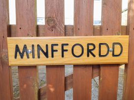 A wooden sign with the word Minffordd attached to a wooden fence at Minffordd in Pandy Tudur near Betws-Y-Coed