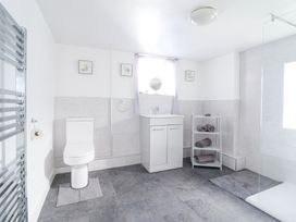A bathroom with a toilet sink cabinet towels and a walk-in shower at Minffordd in Pandy Tudur near Betws-Y-Coed