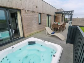 An outdoor area with a hot tub and dining set at Dahlia in Portreath