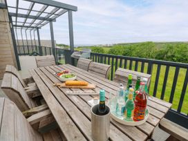 An outdoor dining area with a table and drinks at Dahlia in Portreath
