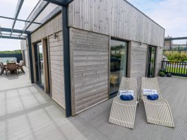 A patio area with loungers and a table at Dahlia in Portreath