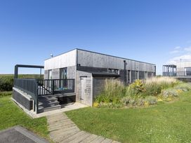 A building with a deck and garden at Dahlia in Portreath