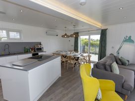A living room with a kitchen island and dining area at Dahlia in Portreath