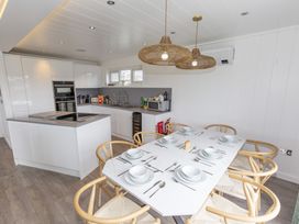 A kitchen with a dining table and chairs at Dahlia in Portreath