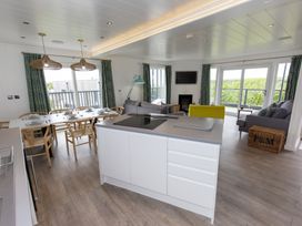A living room with a dining area and kitchen at Dahlia in Portreath