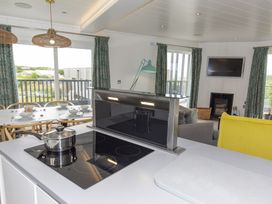 A kitchen with an induction hob and dining table at Dahlia in Portreath