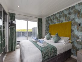 A bedroom with a bed and television at Dahlia in Portreath