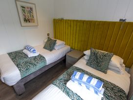 A bedroom with two single beds and towels at Dahlia in Portreath