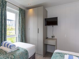 A bedroom with a bed and television at Dahlia in Portreath