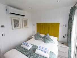 A bedroom with a bed and artwork on the wall at Dahlia in Portreath