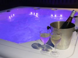 A hot tub with champagne and glasses at Dahlia in Portreath