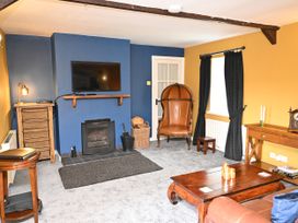 A living room with a television and fireplace at Petty Knowes Cottage Rochester near Otterburn