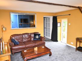 A living room with a sofa and coffee table at Petty Knowes Cottage in Rochester near Otterburn