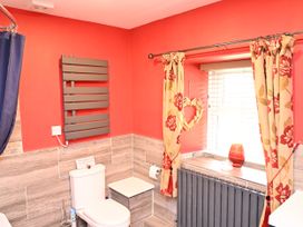 A bathroom with a toilet and a radiator at Petty Knowes Cottage Rochester near Otterburn