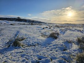 A snowy landscape with grass and hills at Petty Knowes Cottage Rochester near Otterburn