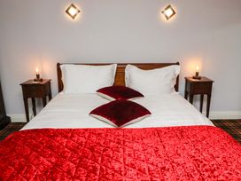 A bedroom with a bed and bedside tables at Petty Knowes Cottage Rochester near Otterburn