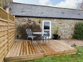 A deck with a table and chairs at Petty Knowes Cottage Rochester near Otterburn