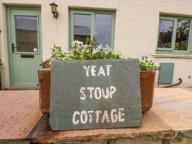 A sign indicating Yeat Stoup Cottage outside a building in Cockermouth
