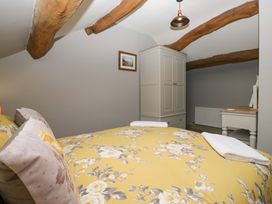 A bedroom with a bed and wardrobe at Yeat Stoup Cottage in Cockermouth