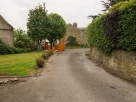 A road bordered by grass and trees at Yeat Stoup Cottage in Cockermouth
