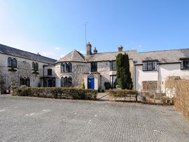 A historic building with arched windows and a blue door with a gravel parking area in front at Alway in Lifton
