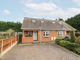 A brick semi detached house with skylights and a paved driveway surrounded by fencing and shrubbery at Rooster in Stourport-On-Severn