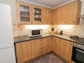 A kitchen corner with wooden cabinets a microwave toaster and a knife block at Rooster in Stourport-On-Severn