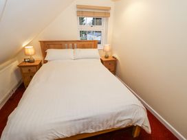 A bedroom with a wooden bed and white bedding two bedside tables with lamps and a window at Rooster in Stourport-On-Severn