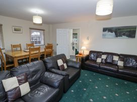 A living room with leather sofas a wooden dining table with chairs and a lamp at Hen and Chickens in Stourport-On-Severn