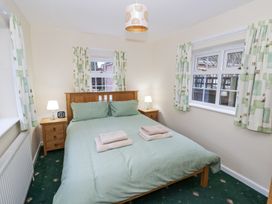 A bedroom with a double bed two bedside tables lamps windows with curtains and towels on the bed at Hen and Chickens in Stourport-On-Severn
