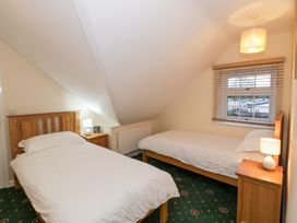 A bedroom with two single beds bedside tables lamps and a window with blinds at Hen and Chickens in Stourport-On-Severn
