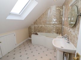 A bathroom with a bathtub shower and sink under a skylight at Hen and Chickens in Stourport-On-Severn