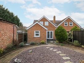 A backyard with a circular stone path and shrubs near a brick house at Hen and Chickens in Stourport-On-Severn