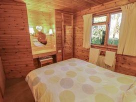 A bedroom with a bed near a window and a small dressing table with lights at Goldcrest in Withern near Alford