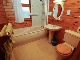 A bathroom with a bath shower toilet sink mirror and towels at Goldcrest in Withern near Alford