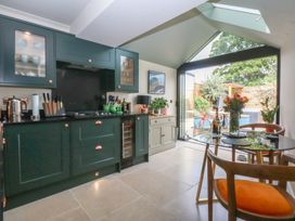A kitchen with cabinets and dining area at Hilltop Cottage in Conwy
