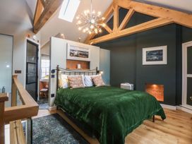 A bedroom with a bed and a chair at Hilltop Cottage in Conwy