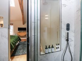 A bathroom with a shower and a view of a bedroom at Hilltop Cottage in Conwy