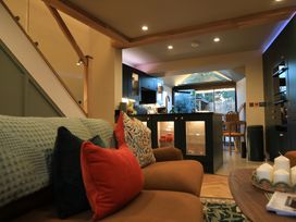 A living room with a sofa and kitchen in the background at Hilltop Cottage in Conwy