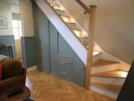 A staircase with storage cabinets in a hallway at Hilltop Cottage in Conwy