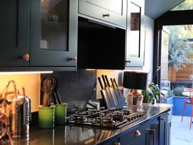A kitchen with cabinets and utensils at Hilltop Cottage in Conwy