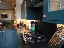 A kitchen with a stove and kitchen cabinetry at Hilltop Cottage in Conwy
