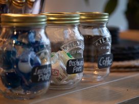 Jars containing laundry pods, dishwasher pods, and coffee at Hilltop Cottage in Conwy