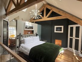 A bedroom with a bed and a light fixture at Hilltop Cottage in Conwy