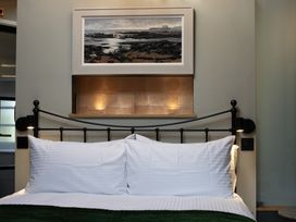 A bedroom with a bed and a painting at Hilltop Cottage in Conwy