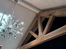 A chandelier and wooden beams in a room at Hilltop Cottage Conwy