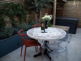 A garden with a table, bottles, and chairs at Hilltop Cottage in Conwy