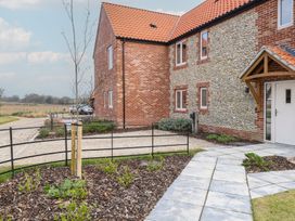 The exterior of a brick and stone house with a tiled roof a paved pathway and a small garden bed at The Hideaway Cromer in Northrepps near Overstrand