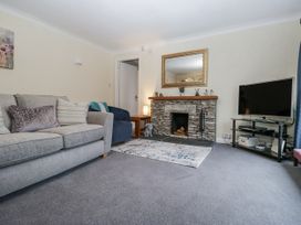 A living room with a fireplace and TV at Beech Brae Kendal