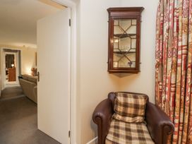 A hallway with an armchair and wall cabinet at Beech Brae in Kendal